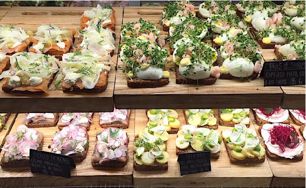 Different kinds of open faced sandwiches with toppings such as smoked salmon and radish